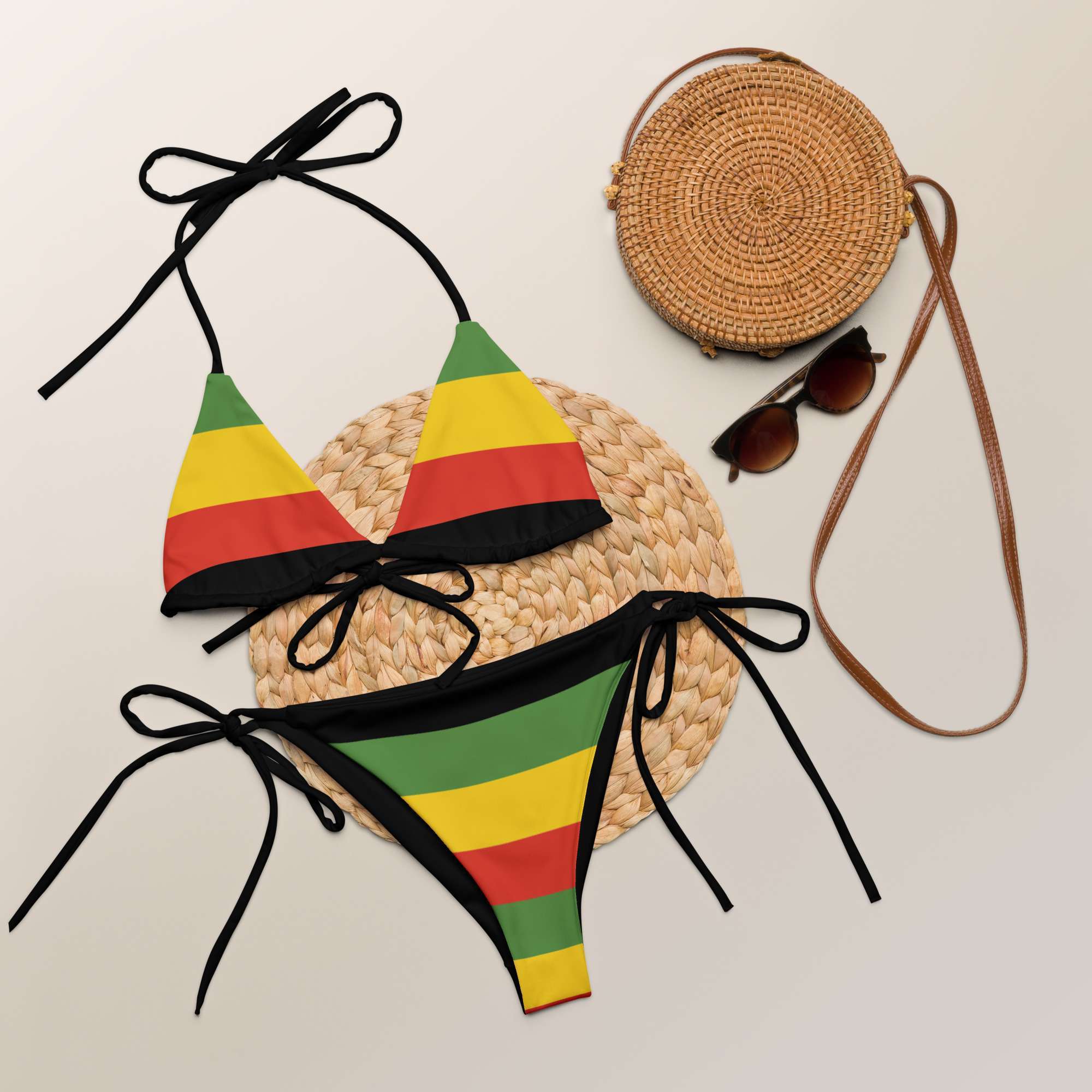 Rasta string bikini in the Rastafarian colors flat view styled. Soft and stretchy material up to 6XL sizing. Black ties and lining. Multiple ways to tie and style.