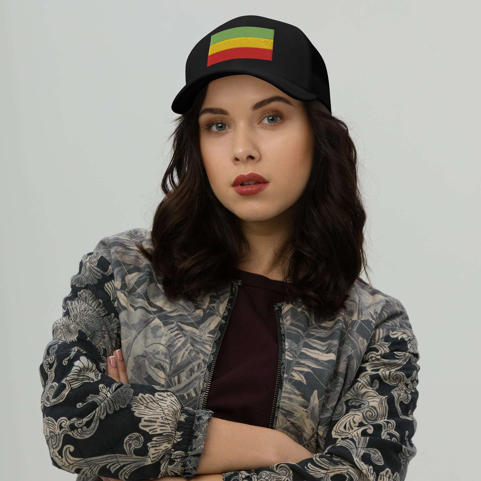 Rastafari cap front female model view with embroidered Rasta flag across the front. Red gold and green. Black cap great for island vacation or Reggae Festival.