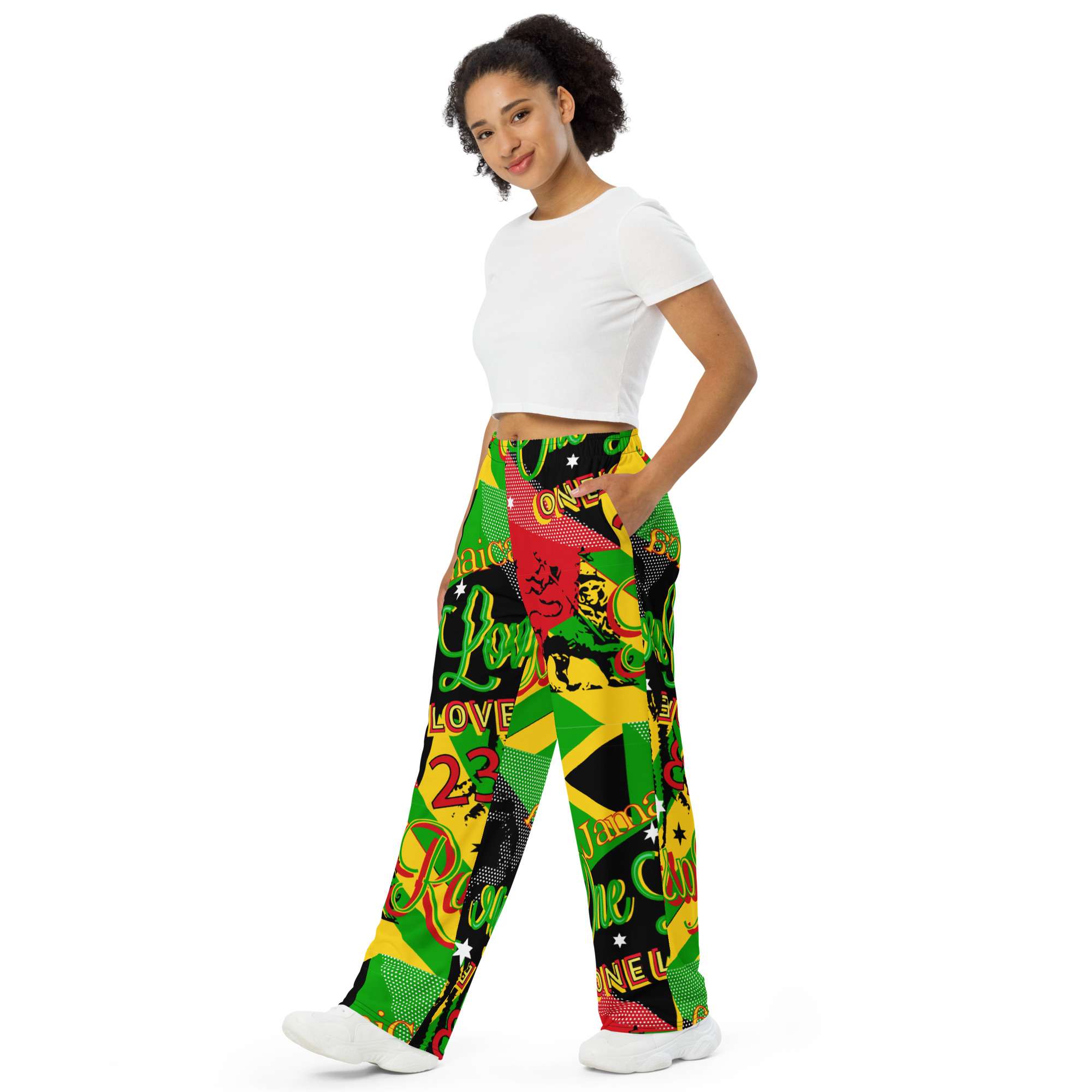 Rasta Reggae Party Wide Leg Pants side female model view in Jamaican and Rastafarian pattern featuring Reggae colors and One Love. Rastaseed brand merchandise.